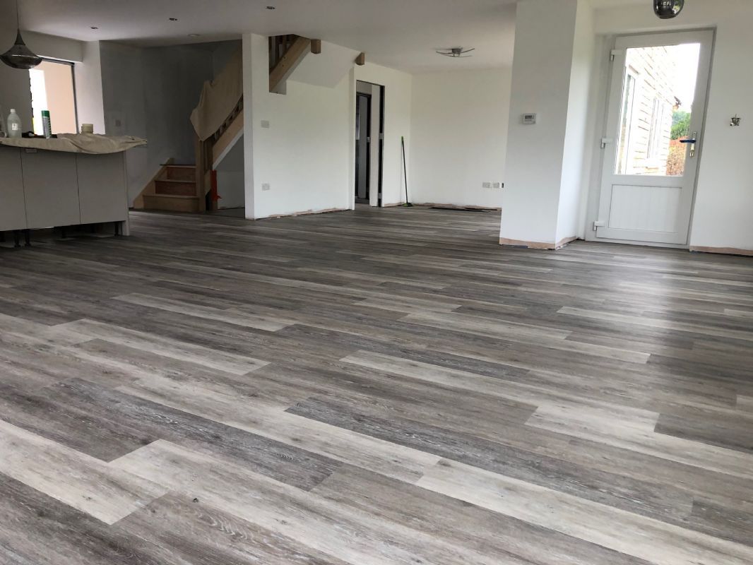 Grey plank luxury vinyl through an open-plan living space