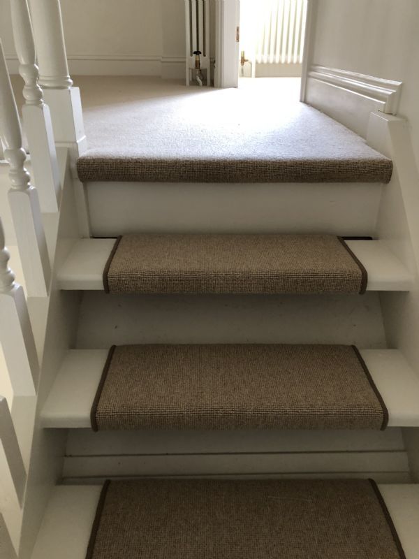 Bound sisal stair pads fitted up painted stairs to a carpeted landing