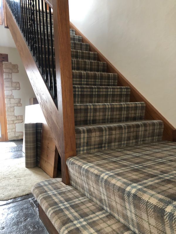 Tartan carpet Shaun fitted over a winding wooden staircase, with a flagstone hall below